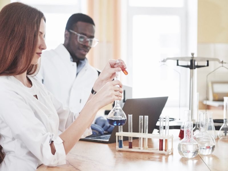 Laboratory laboratories conduct experiments in a chemical laboratory in transparent flasks. Output formulas.
